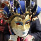 Colorful Masked Figure in Elaborate Costume with Feathers and Jewels