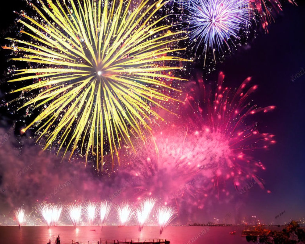 Colorful fireworks show above water with docks and onlookers.