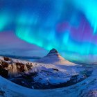 Majestic aurora borealis over snowy mountain landscape