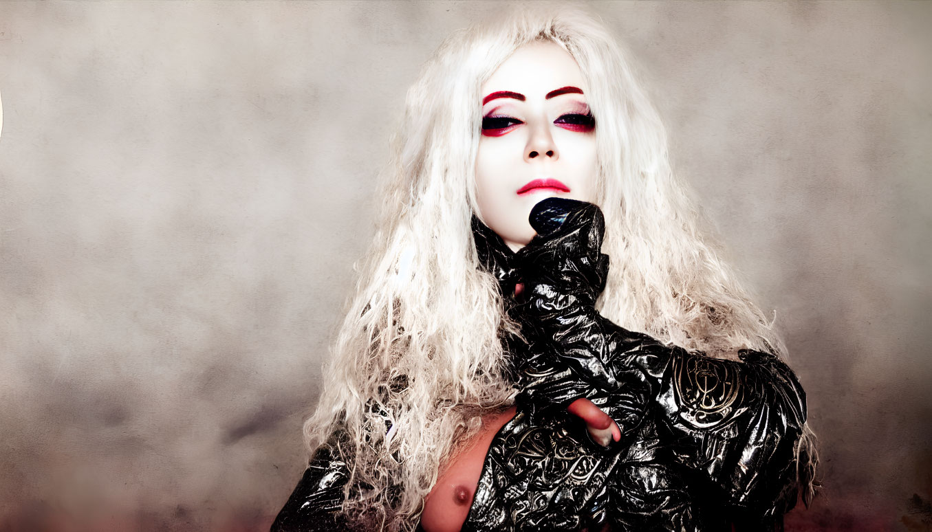 Platinum blonde person with red makeup in black outfit and rose patterns
