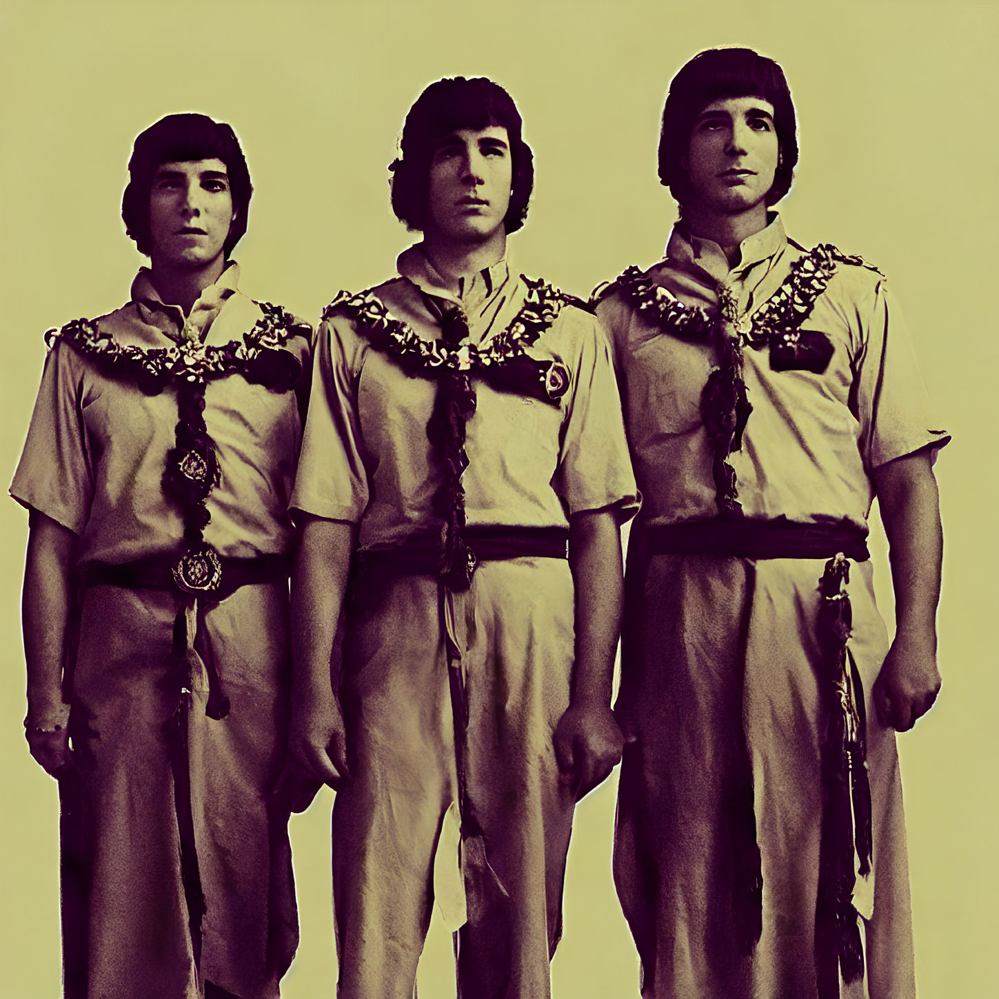 Three individuals in matching scout uniforms standing in a row