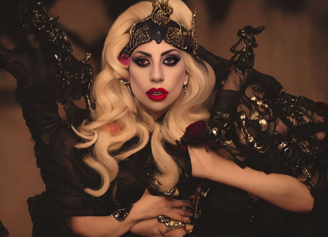 Person with Dramatic Makeup and Ornate Headpiece in Black and Gold Attire poses against Blurred