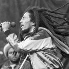 Monochrome image of dreadlocked performer singing on stage