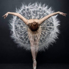 Ballet dancer in pointe shoes and tutu amidst swirling smoke