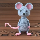 Grey Crocheted Toy Mouse with Pink Ears on Wooden Surface