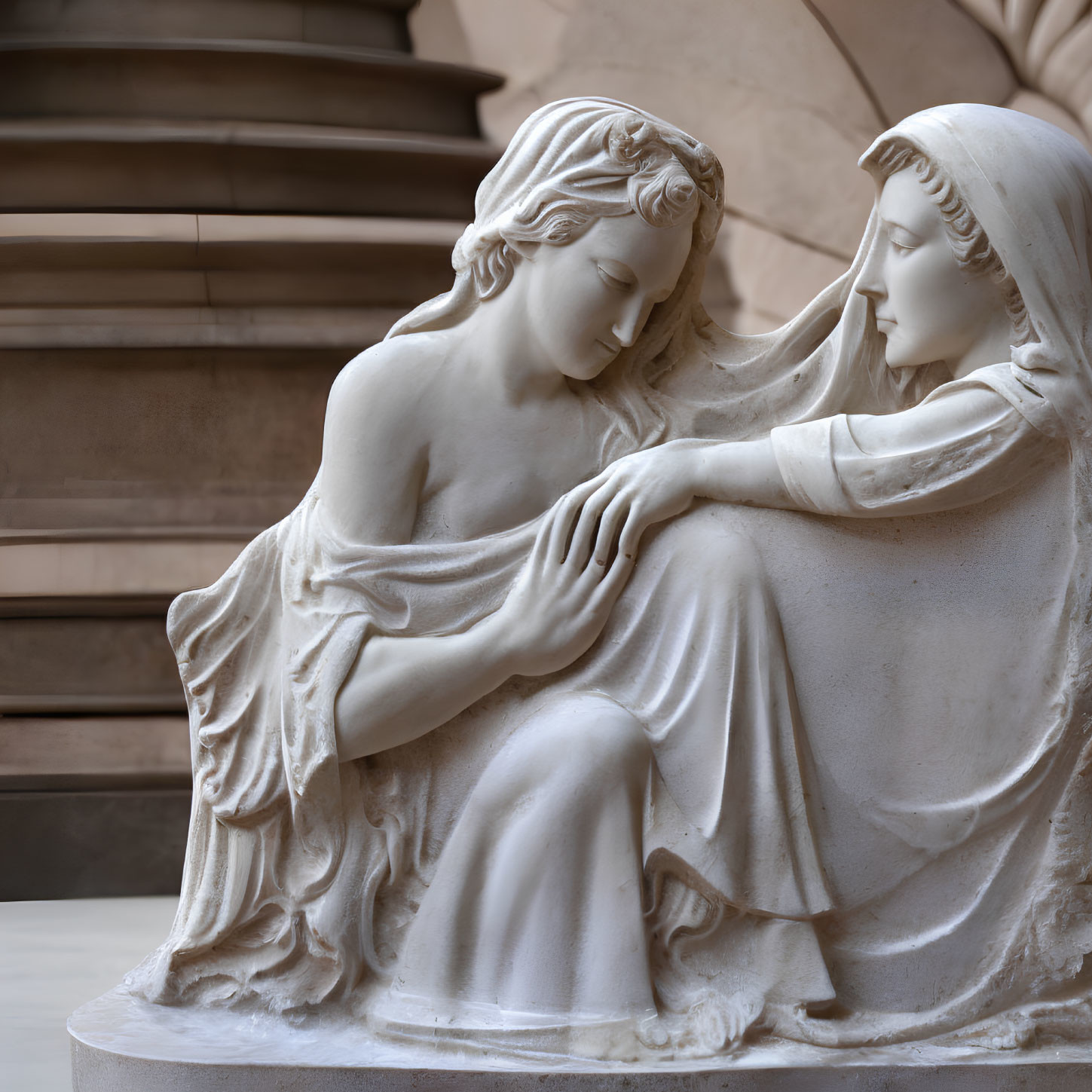 Marble statue of two figures in a tender moment against architectural backdrop