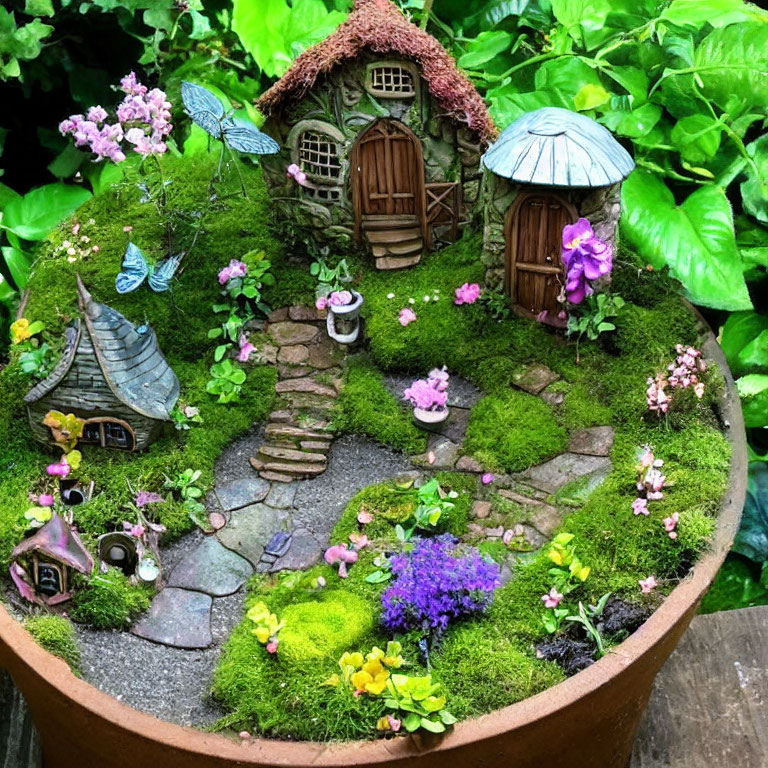Miniature fairy garden with house, pathway, butterflies, and lush greenery