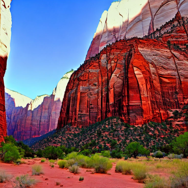 Red Sandstone Canyon: Towering Cliffs, Green Shrubs, Blue Sky