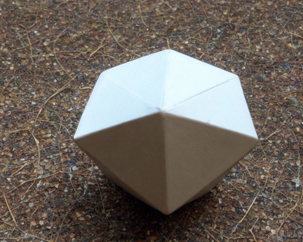 White Origami Octahedron on Textured Brown Surface