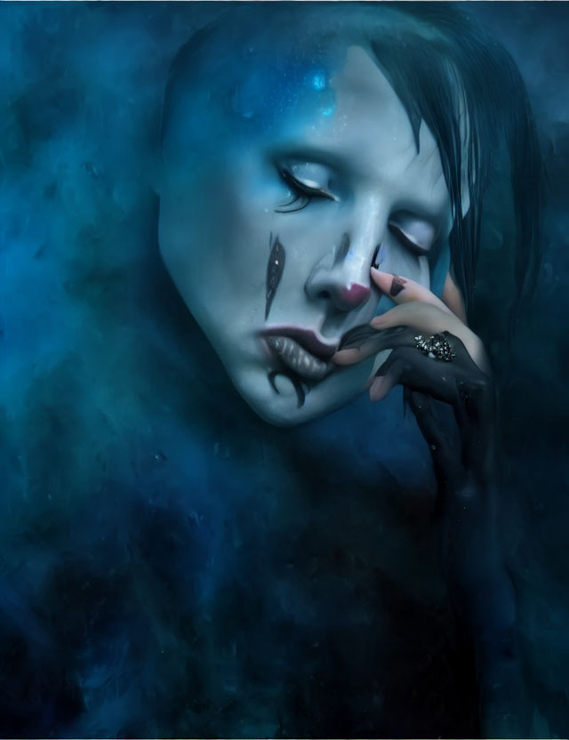 Person with blue and black theatrical makeup tears in misty blue backdrop