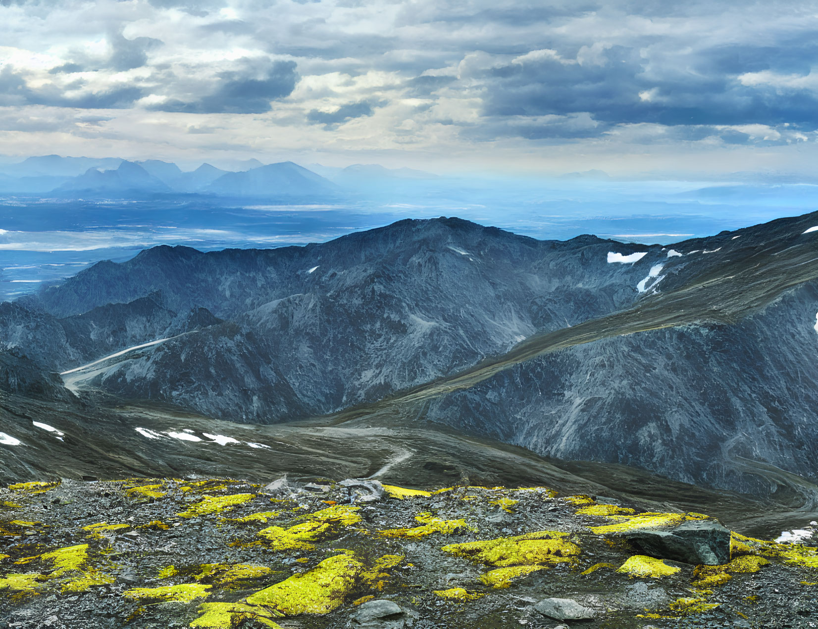 Rocky Mountain Peaks with Snow Patches and Vibrant Yellow Lichen