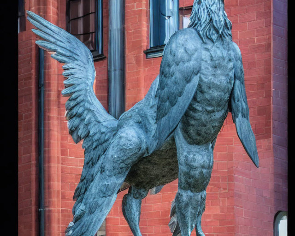 Detailed metal griffin sculpture in front of red brick building