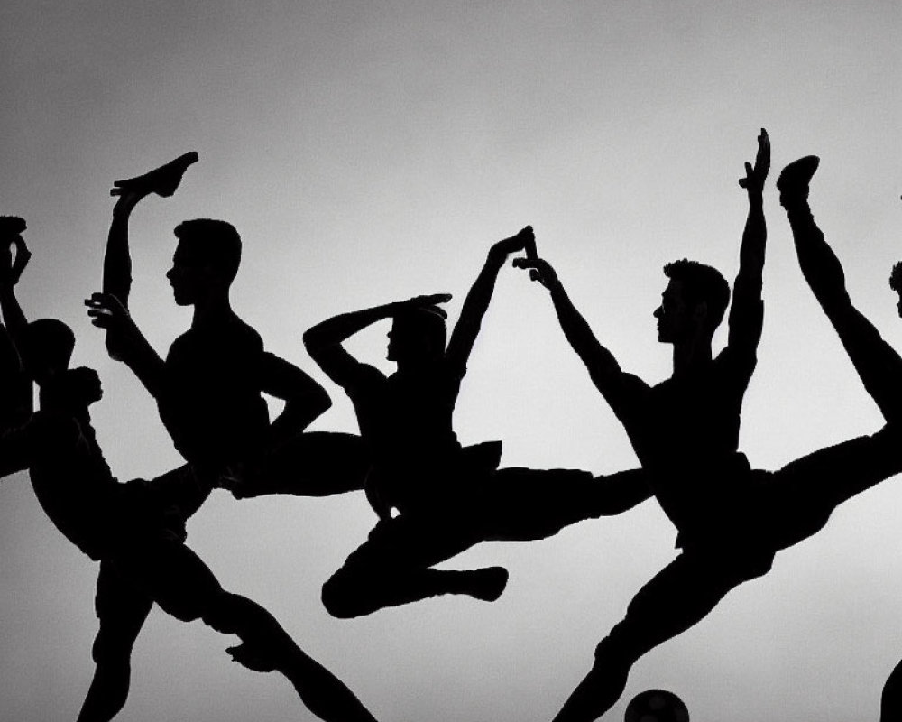 Dynamic Silhouetted Dancers in Performance Against Lit Background