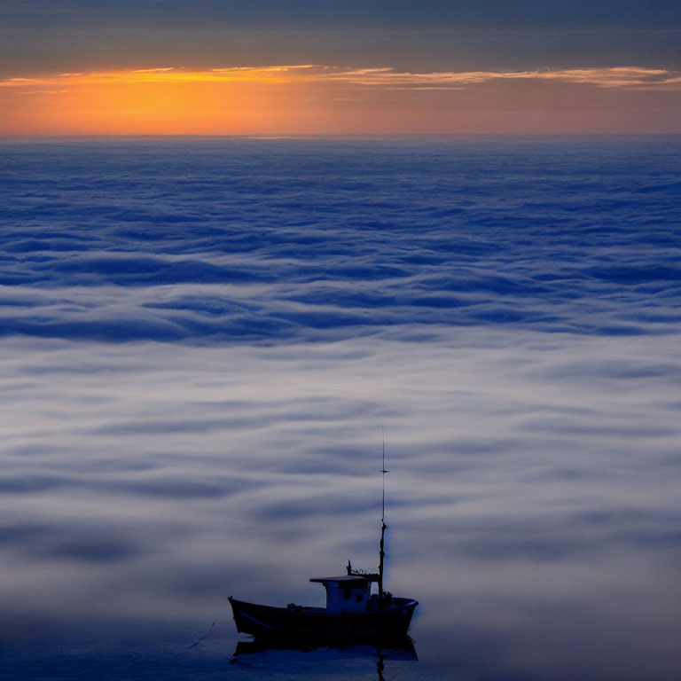 Sunrise over misty clouds with lone boat