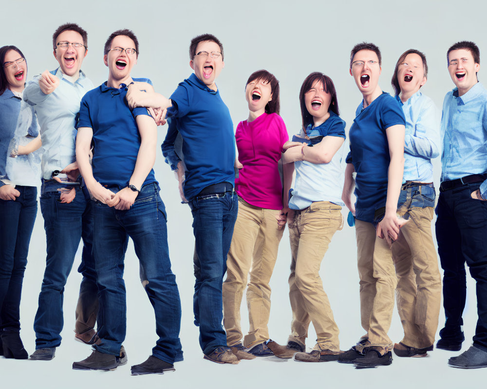 Group of people in casual attire laughing against light blue background
