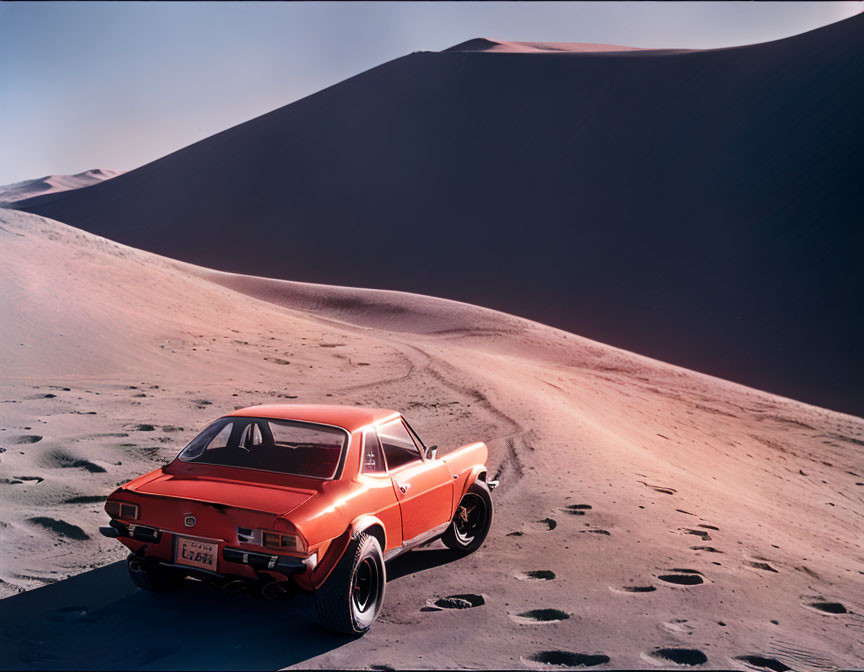 Vintage Orange Car in Desert with Sand Dunes and Hazy Sky