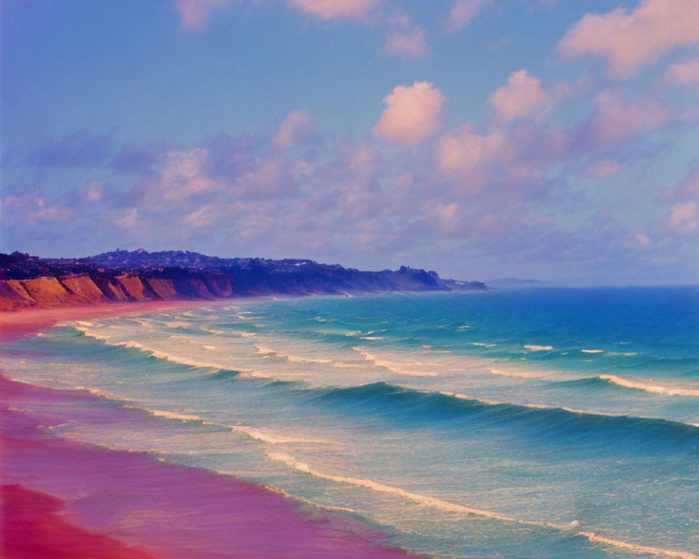 Scenic beach landscape with blue to pink gradient, waves, red cliffs, and cloudy sky