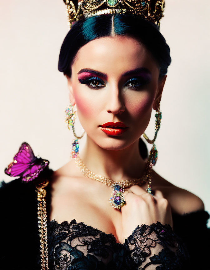 Elegant woman with crown and butterfly in striking makeup pose