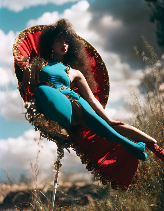 Woman in Teal and Red Outfit Lounging on Ornate Chair in Field