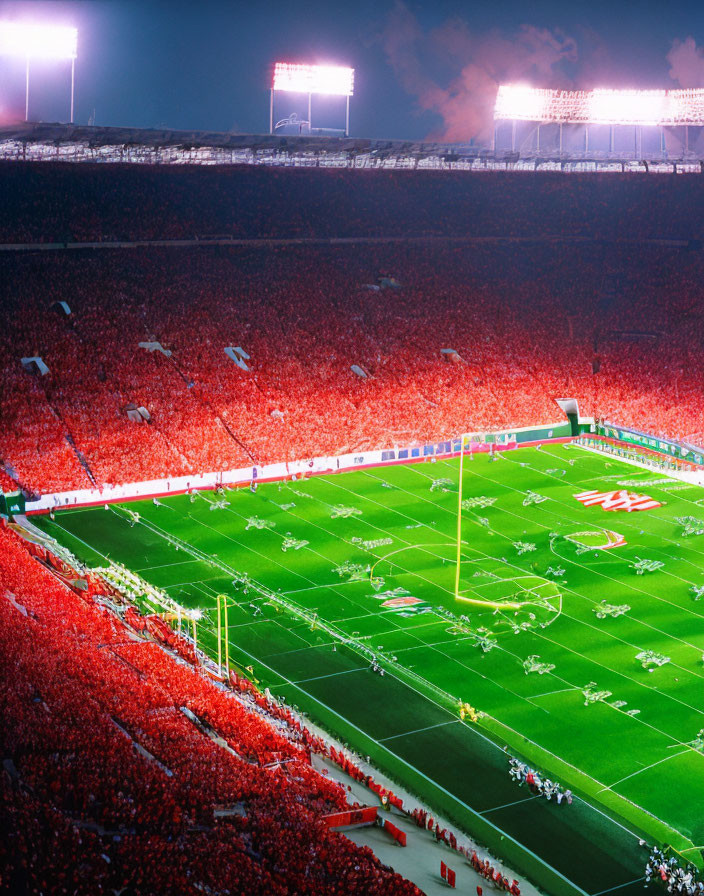 Nighttime American Football Game with Vibrant Red Crowd and Bright Field Illumination