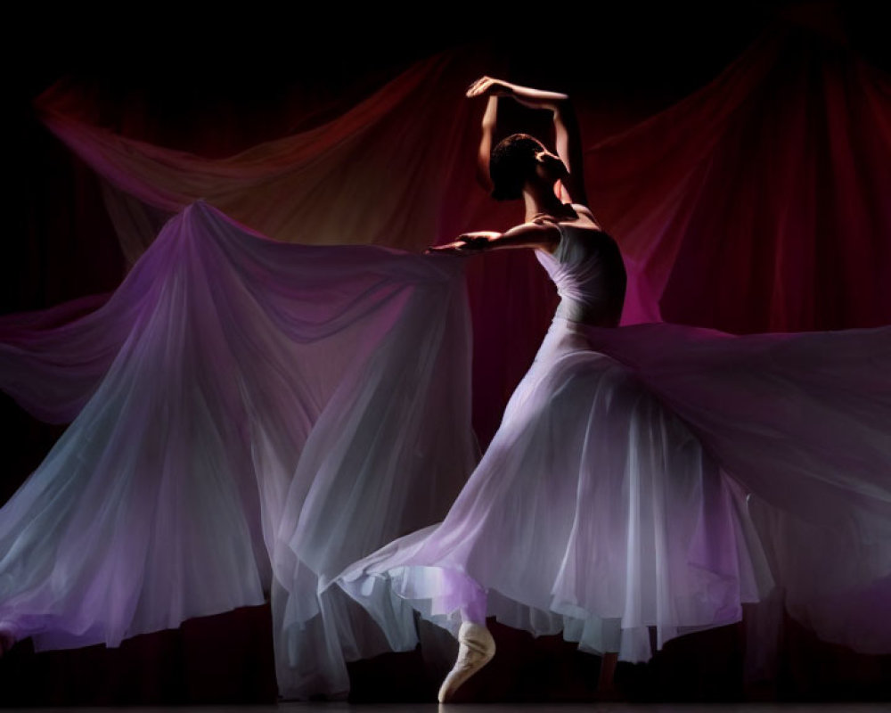 Ballet dancer in white tutu with swirling purple and pink fabric on dark background