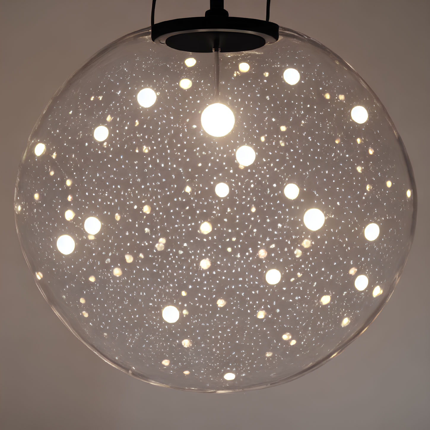 Spherical pendant light resembling star-filled night sky