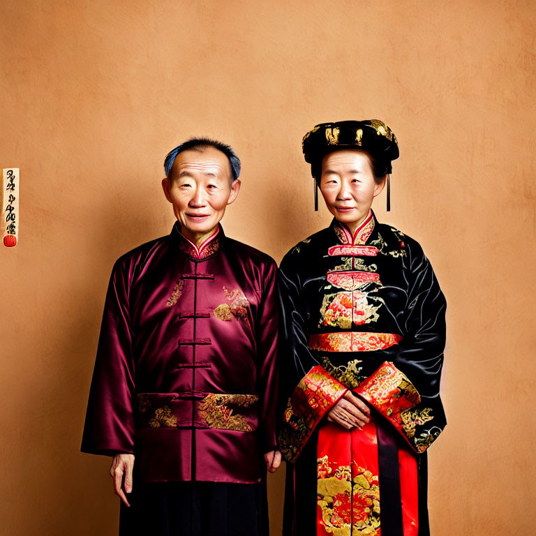 Elderly Couple in Traditional Chinese Attire Against Warm Orange Background