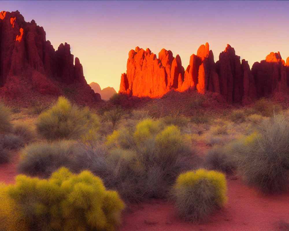 Scenic sunset illuminating rocky desert landscape with green shrubs.
