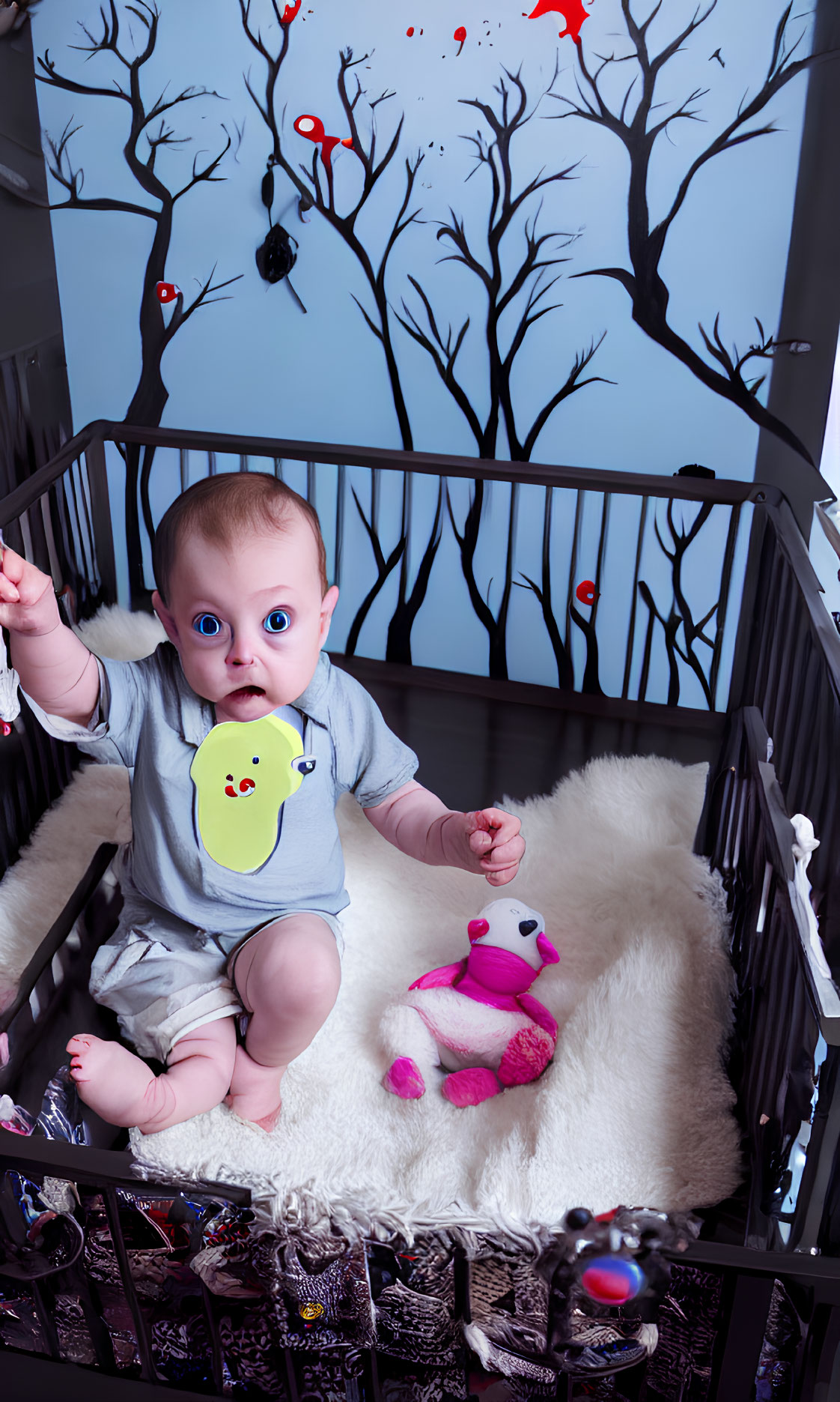 Wide-eyed baby in bib with pink toy in crib against whimsical tree mural