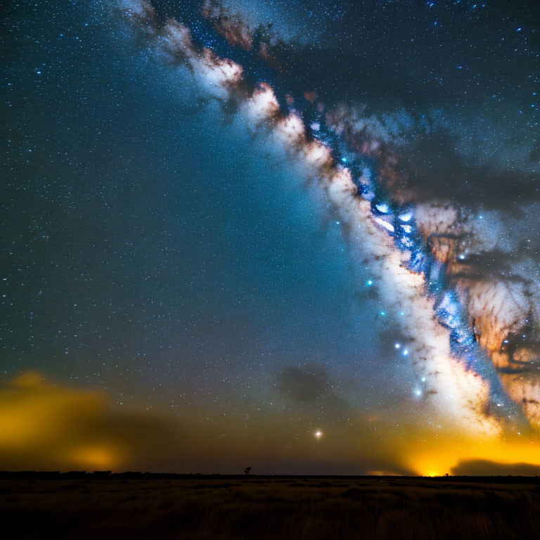 Vibrant Milky Way over grassy field under starry night sky