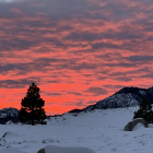 Fiery red and purple sunset over snowy landscape