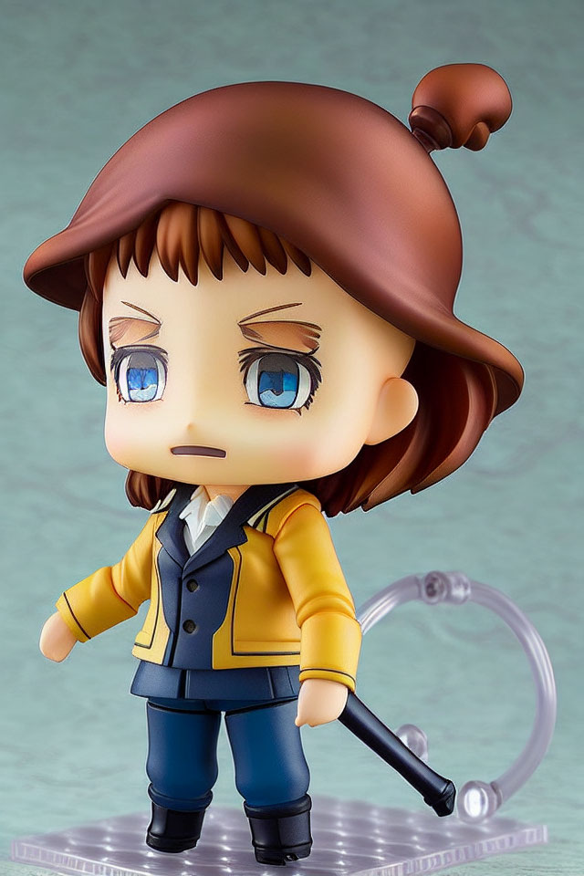 Brown-haired chibi figurine in yellow jacket, blue pants, holding black baton