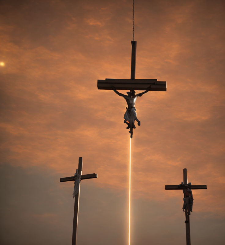 Three Crosses Silhouetted in Orange Sky with Central Cross Illuminated
