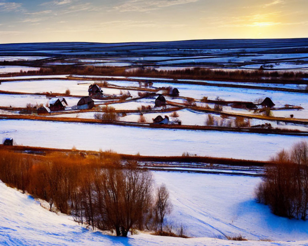 Snow-covered rural landscape with farms and winding roads at sunset