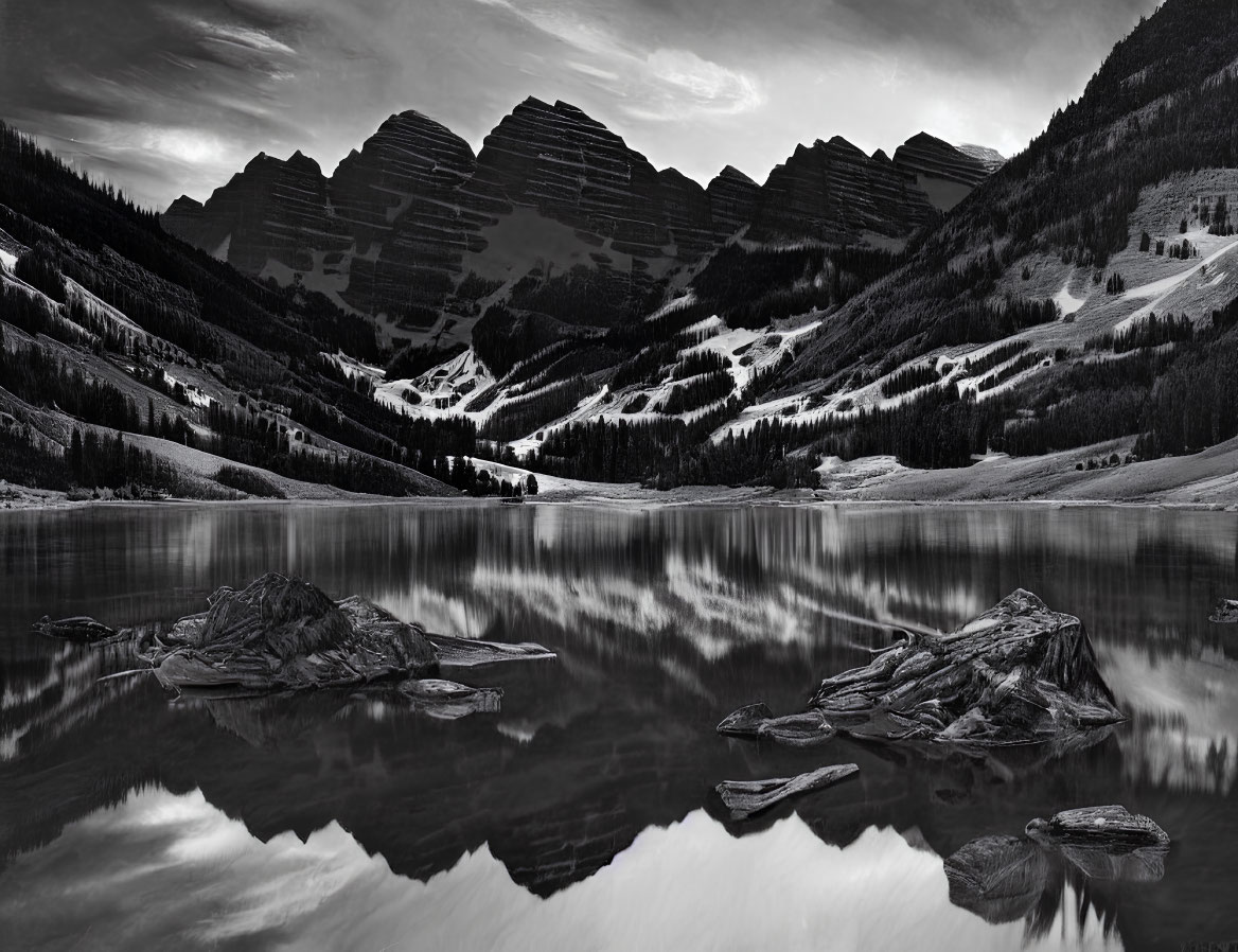 Serene monochrome landscape of lake, mountains, and forests under cloud-streaked sky