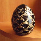 Intricate jeweled egg with gold and blue patterns on cosmic background