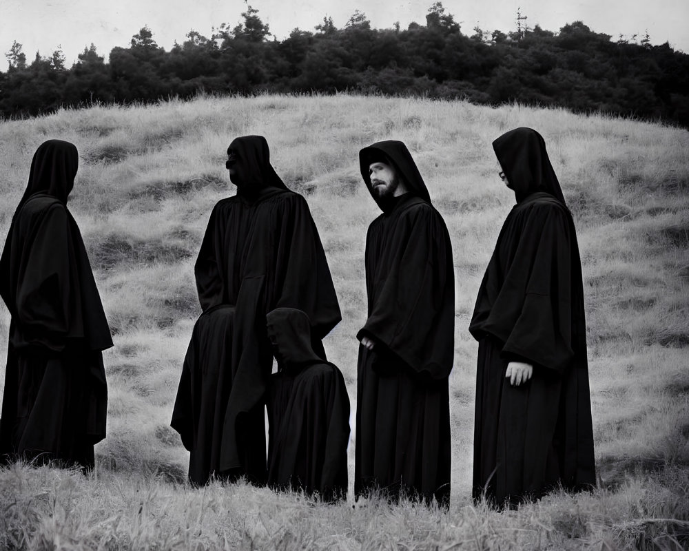 Four individuals in black cloaks in monochromatic field with forested hill