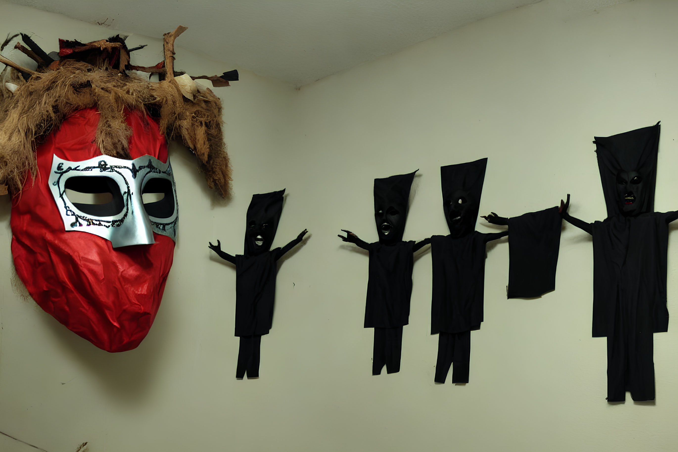 Large red and white mask on wall with small black figures against light background