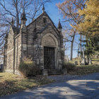 Ornate Mausoleum in Autumn Cemetery with Fog