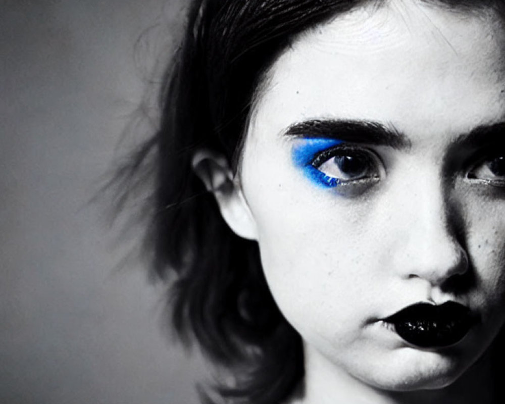 Monochrome portrait featuring bold blue eyeshadow and black lipstick