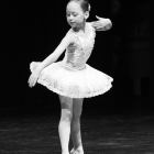 Geometric low-poly ballerina with sparkling tutu and tiara on dark background