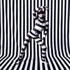 Eerie alien-like figure with oversized eyes against black-and-white striped backdrop