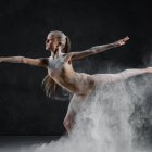 Ballet dancer in flowy skirt surrounded by swirling mist
