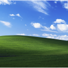 Scenic view of rolling green hills under vibrant blue sky