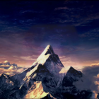 Snow-capped mountain peak in twilight sky with clouds