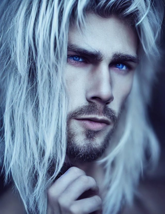 Portrait of person with striking blue eyes and long wavy white hair gazing at camera.