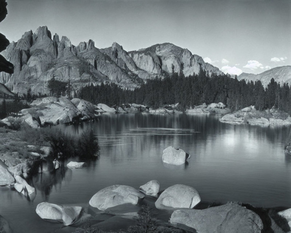 Monochrome landscape with lake, boulders & mountains