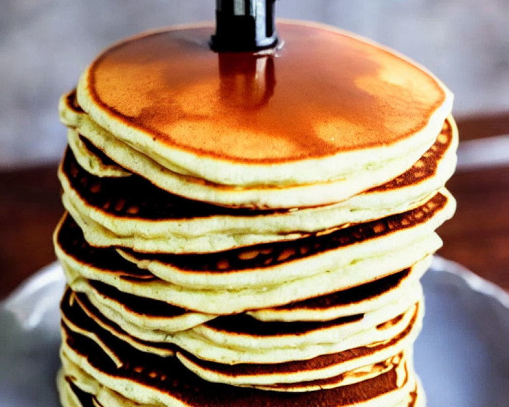 Golden Brown Pancakes with Pouring Syrup on Plate