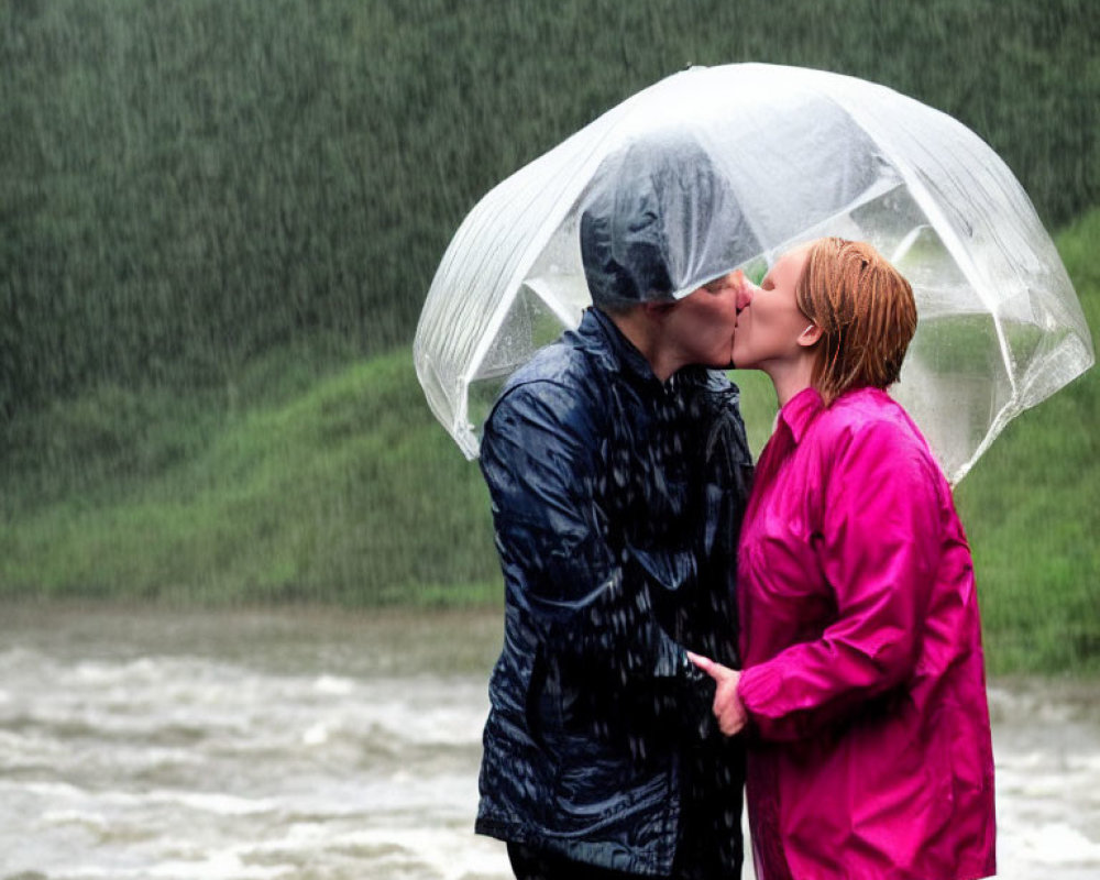 Couple kissing under transparent umbrella in rain