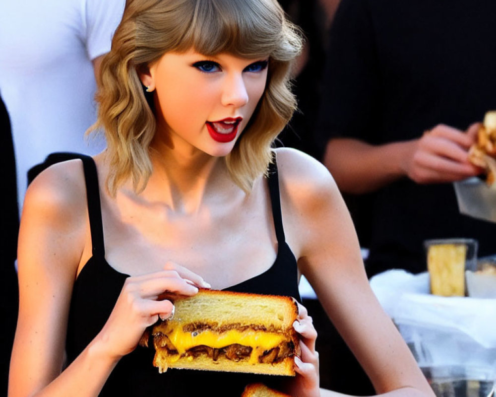 Blonde woman with red lipstick holding grilled cheese sandwich outdoors